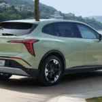 Achter driekwart aanzicht van Hongqi EHS5 met LED achterlichten, achterspoiler, nummerplaat gebied, en algehele SUV-proporties in schilderachtige kustomgeving
