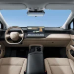 Interieur beeld van Hongqi EHS5 elektrische SUV met beige lederen dashboard, groot centraal touchscreen display, stuurwiel met Hongqi logo, en panoramisch schuifdak