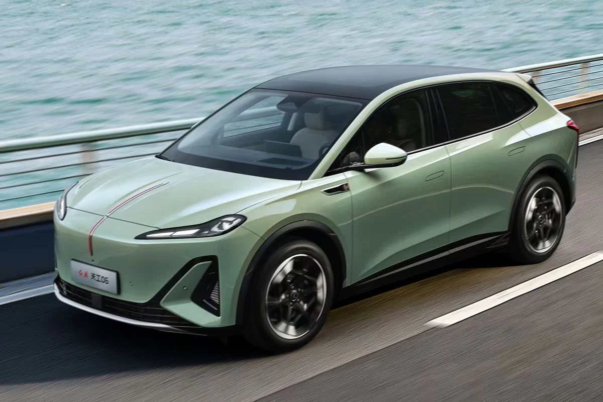 Hongqi EHS5 elektrische SUV in beweging op waterfront weg met dynamische prestaties, groene exterieur kleur, en modern aerodynamisch design met rode accent streep