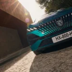 Lage hoek vooraanzicht van de 2025 Peugeot 308 facelift in teal groen met dramatische styling en nieuw bumperdesign en aerodynamische luchtinlaten