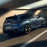 Dynamisch achteraanzicht van de 2025 Peugeot 308 facelift in grijs met gestroomlijnd design en diagonale LED achterlichten tijdens het rijden