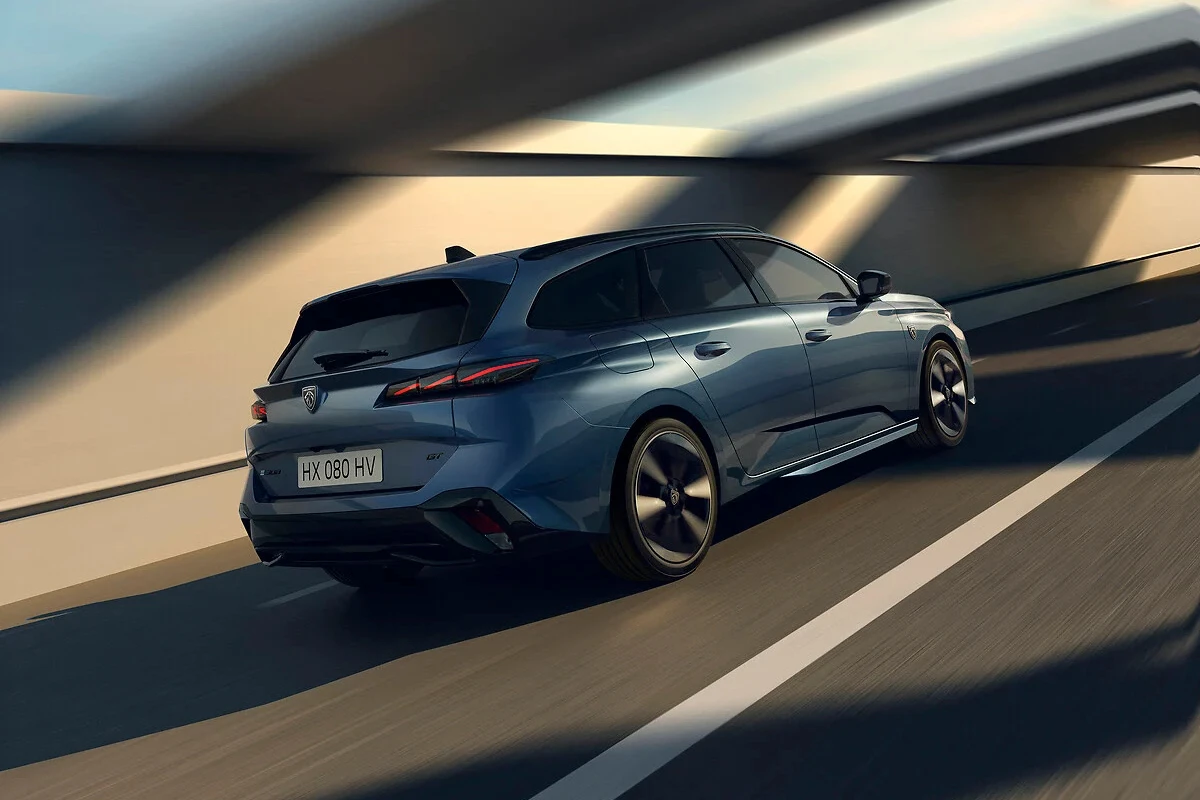 Dynamisch achteraanzicht van de 2025 Peugeot 308 facelift in grijs met gestroomlijnd design en diagonale LED achterlichten tijdens het rijden