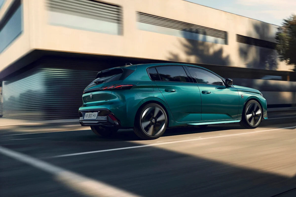 Zijaanzicht van de 2025 Peugeot 308 facelift in teal groen met nieuwe diamant-geslepen lichtmetalen velgen en aerodynamisch carrosserieontwerp tijdens het rijden