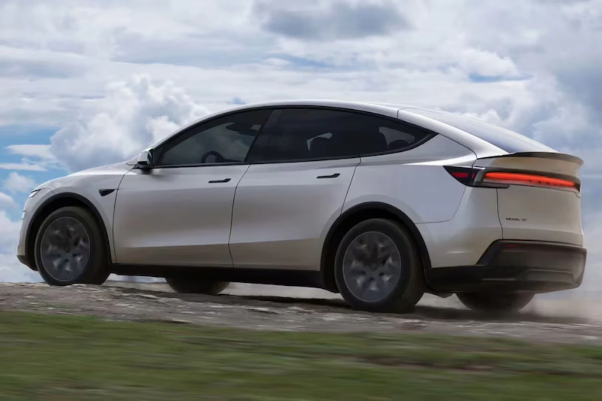 Witte Tesla Model YL vanuit achter driekwart hoek met verlengde afmetingen, herontworpen achterspoiler en grotere achterklep van de 6-zits elektrische SUV