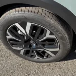 Close-up detail van de 18-inch Amber lichtmetalen velg van de 2025 Citroën C4 met 195/60 R18 Goodyear banden, die het tweekleurige ontwerp toont met asymmetrisch spaakpatroon.