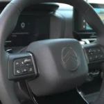 Gedetailleerd zicht op lederen stuurwiel van 2025 Citroën C4 met nieuw logo en geïntegreerde bedieningsknoppen