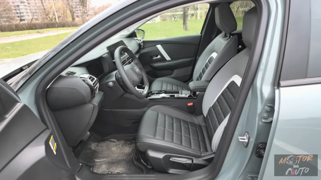 Voorpassagiersruimte van 2025 Citroën C4 met gewatteerde comfortstoelen met driekleurige bekleding en handmatige verstelling