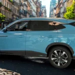 2025 MG HS Hybrid+ in Arctic Blue op drukke stadsstraat vanuit achter drie-kwart hoek, met LED-achterlichtbalk, achterspoiler en stedelijke achtergrond met historische gebouwen