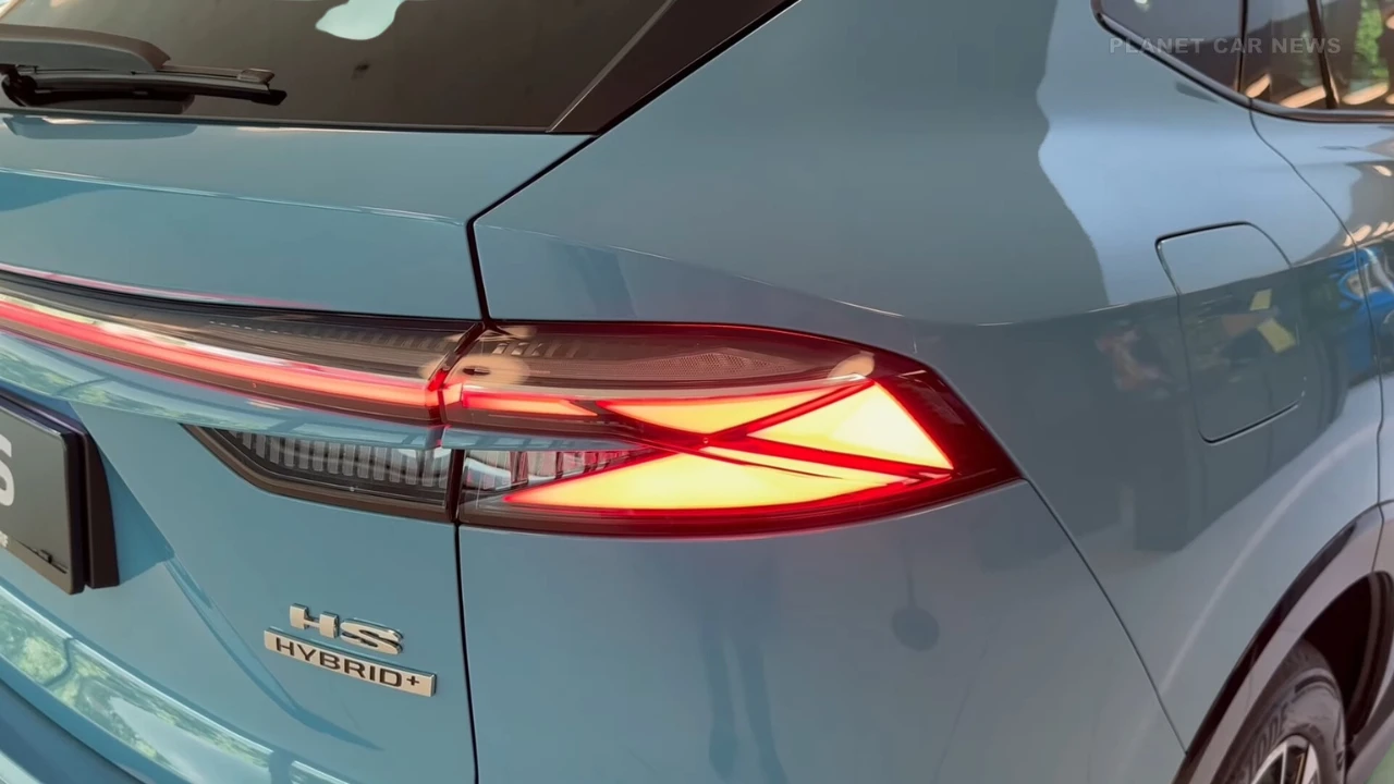 Close-up detailopname van 2025 MG HS achterlicht met verlichte LED-elementen en Hybrid+ badge op Arctic Blue lakwerk