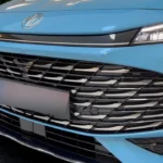 Gedetailleerd zicht op de voorgrille van de 2025 MG HS Hybrid+ met het honingraatpatroon, MG-badge en LED-koplamp configuratie