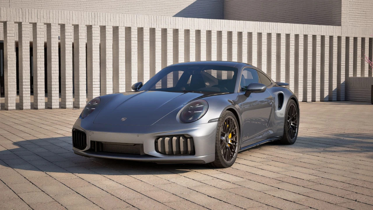 Zilveren 2025 Porsche 911 Turbo S Coupe in buitenomgeving met moderne gebouw achtergrond, voorste driekwart hoek met agressieve aerodynamische styling