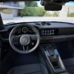 Interieur bestuurder aanzicht van 2025 Porsche 911 Turbo S met stuurwiel, instrumentencluster, centraal infotainment scherm en modern dashboard ontwerp met hybride systeem displays