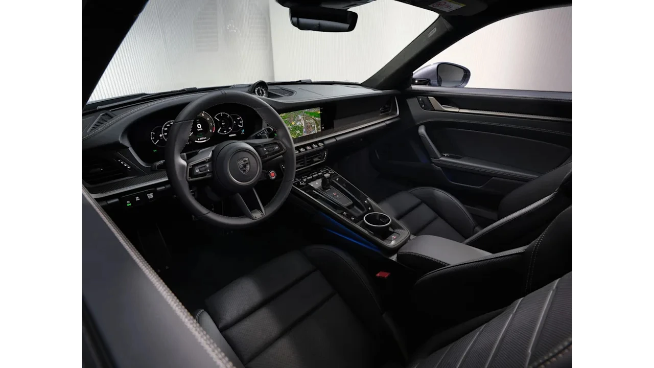 Interieur passagier aanzicht van 2025 Porsche 911 Turbo S met dashboard, middenconsole, sportstoelen, carbon fiber trim en modern infotainment systeem