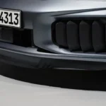 Close-up detail van 2025 Porsche 911 Turbo S voorbumper met grote rechthoekige luchtinlaat roosters met horizontale lamellen voor verbeterde motor en hybride systeem koeling