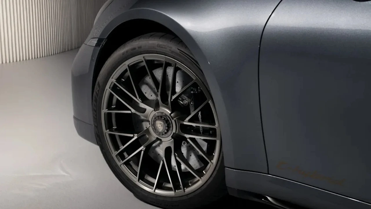 Detail opname van 2025 Porsche 911 Turbo S met meerspaaks lichtmetalen velg met grote keramische remschijf, gele remklauw en Porsche naafkapje
