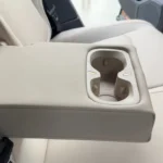 Achter centrale armsteun detail met dubbele bekerhouders en premium materialen, comfort voorzieningen voor achterpassagiers in de ruime cabine met 979mm achter hoofdruimte.