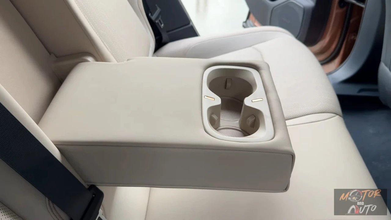 Achter centrale armsteun detail met dubbele bekerhouders en premium materialen, comfort voorzieningen voor achterpassagiers in de ruime cabine met 979mm achter hoofdruimte.