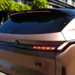 Achter ontwerp detail van de 2026 Lynk & Co 08 met het volledige breedte achterlicht ontwerp, geïntegreerde spoiler, model badges, en strakke achterstyling met verborgen uitlaatmonden typisch voor hybride voertuigen.