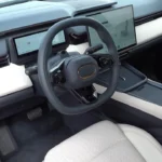 Bestuurders perspectief van de 2026 Lynk & Co 08 met het 4-voudig verstelbare stuurwiel met multifunctionele bedieningsorganen, digitaal instrumentenpaneel, en de integratie van alle voertuigsystemen in het minimalistische cockpit ontwerp.