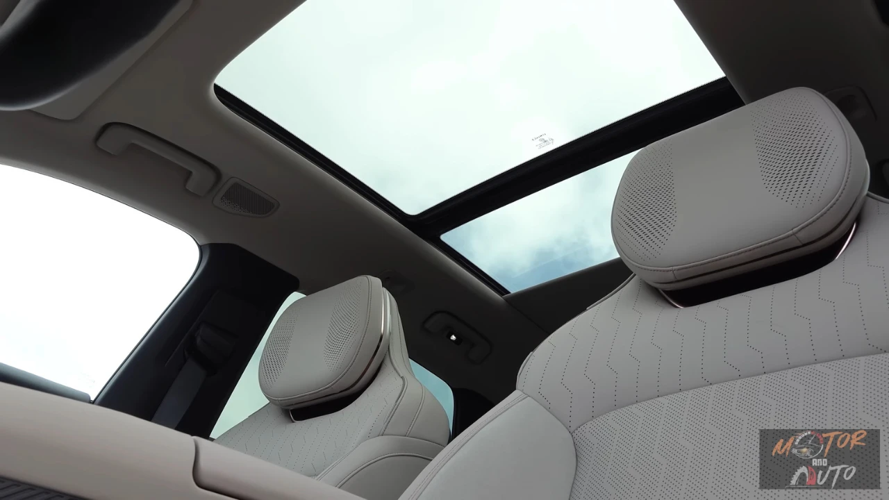 Interieur aanzicht met nadruk op het panoramisch schuifdak dat het ruimtelijke gevoel van de 2,85m wielbasis cabine versterkt, met Harman Kardon luidsprekers geïntegreerd in hoofdsteunen en premium bekleding door het geheel.