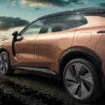 Zij detail foto met nadruk op de 2026 Lynk & Co 08's ontwerpelementen inclusief de onderscheidende wielkast bekleding, deurgrepen, en carrosserie proporties tegen een landelijke landschap achtergrond.