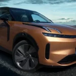 Zijaanzicht van de 2026 Lynk & Co 08 met 4,82m lengte, 2,85m wielbasis en onderscheidende designelementen inclusief het zwevende dakontwerp, kozijnloze ramen en aerodynamisch wielontwerp tegen een schilderachtige waterfront achtergrond.