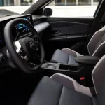 Interieur van de 2026 Nissan Micra met het optionele Chill-bekledingspakket in grijs en beige stof, wat een heldere en luchtige cabine-sfeer creëert met moderne ontwerpelementen.