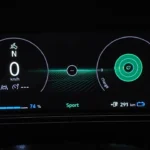Het 10,3-inch TFT digitale instrumentenpaneel van de 2026 Nissan Micra toont Sport-modus met 74% batterijlading en 291km resterende actieradius, met modern cirkelvormig meterdesign.