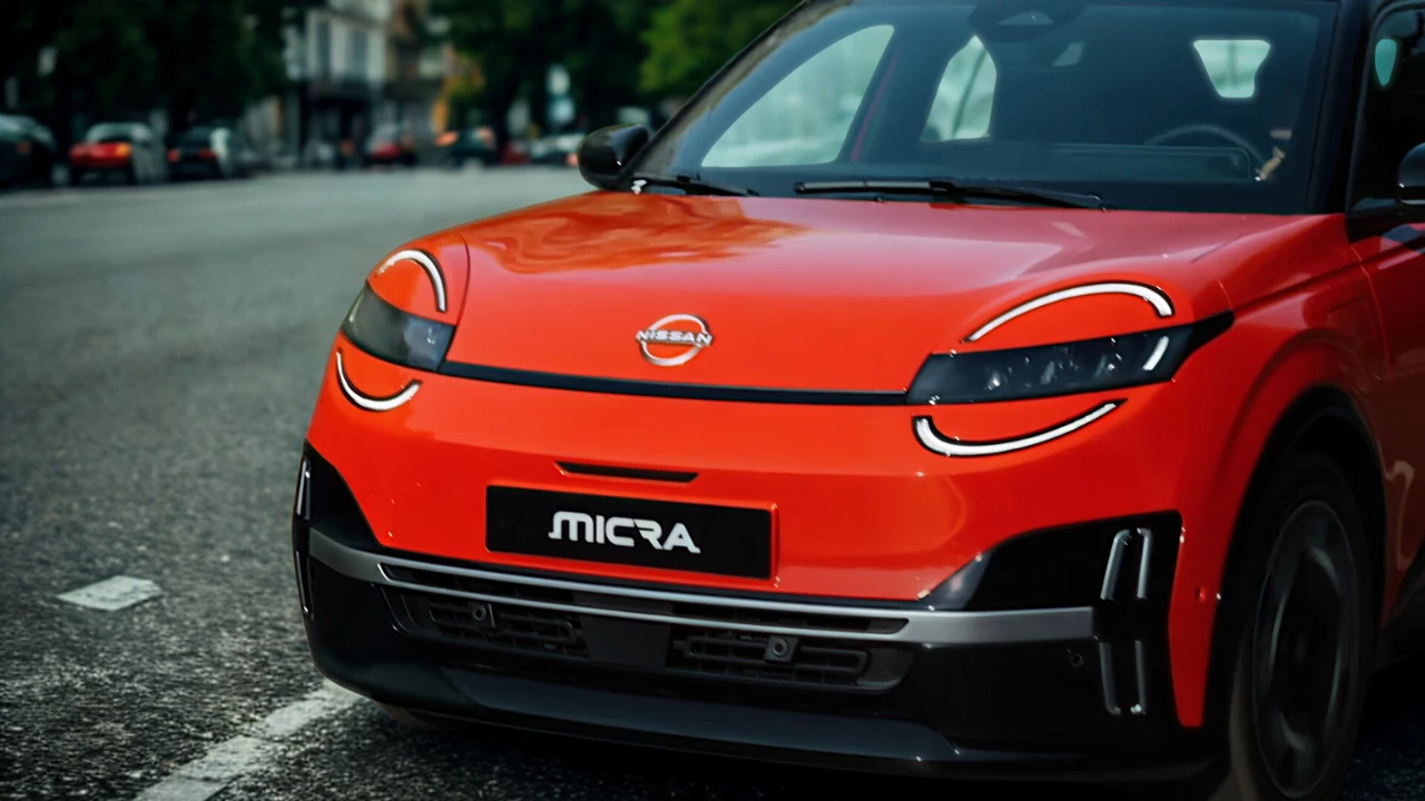 Lage hoek aanzicht van rode 2026 Nissan Micra op stadsstraat met nadruk op frontontwerp met ronde LED-koplampen en moderne bumperstyling