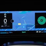 2026 Nissan Micra instrumentendisplay met geïntegreerde Google Maps met routenavigatie, batterijstatus op 74% en Sport-modus indicator