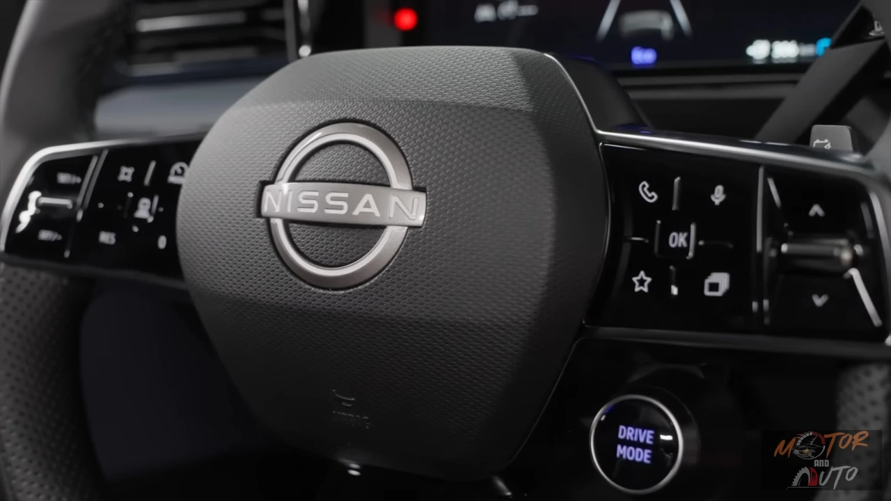 Close-up van Nissan Micra stuurwiel met Nissan-logo in het midden, bedieningsknoppen op spaken en Drive Mode-knop zichtbaar