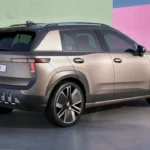 Achter-driekwart aanzicht van de 2026 Skoda Epiq elektrische SUV met T-vormige LED-achterlichten, SKODA-letters op de achterklep, achterspoiler, kenmerkend onderste bumperdesign met verticale luchtuitlaten en EPIQ-kentekenplaat op een gradiënt studio-achtergrond