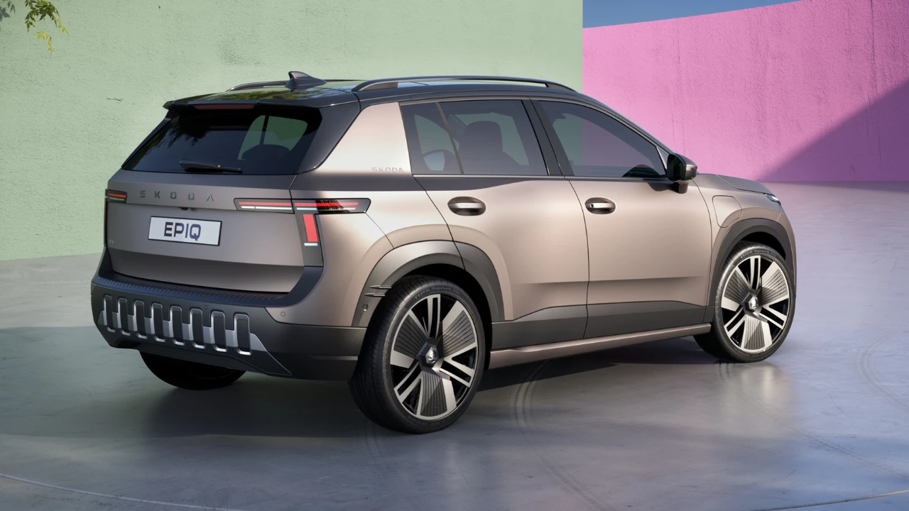 Achter-driekwart aanzicht van de 2026 Skoda Epiq elektrische SUV met T-vormige LED-achterlichten, SKODA-letters op de achterklep, achterspoiler, kenmerkend onderste bumperdesign met verticale luchtuitlaten en EPIQ-kentekenplaat op een gradiënt studio-achtergrond