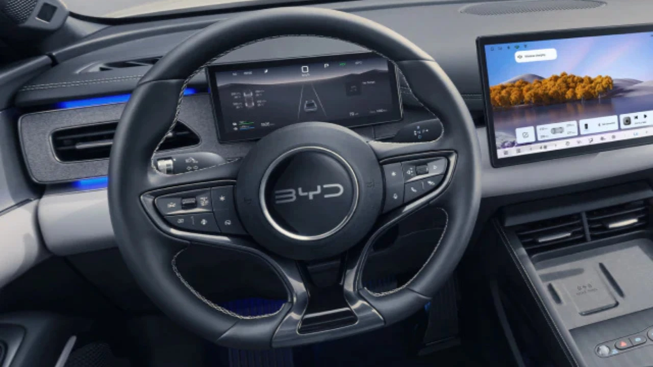 Gedetailleerd zicht op het moderne stuurwiel van de BYD Seal 6 DM-i met geïntegreerde bedieningselementen en de 8,8-inch LCD digitale instrumentencluster die hybridesysteeminformatie en voertuiggegevens toont.
