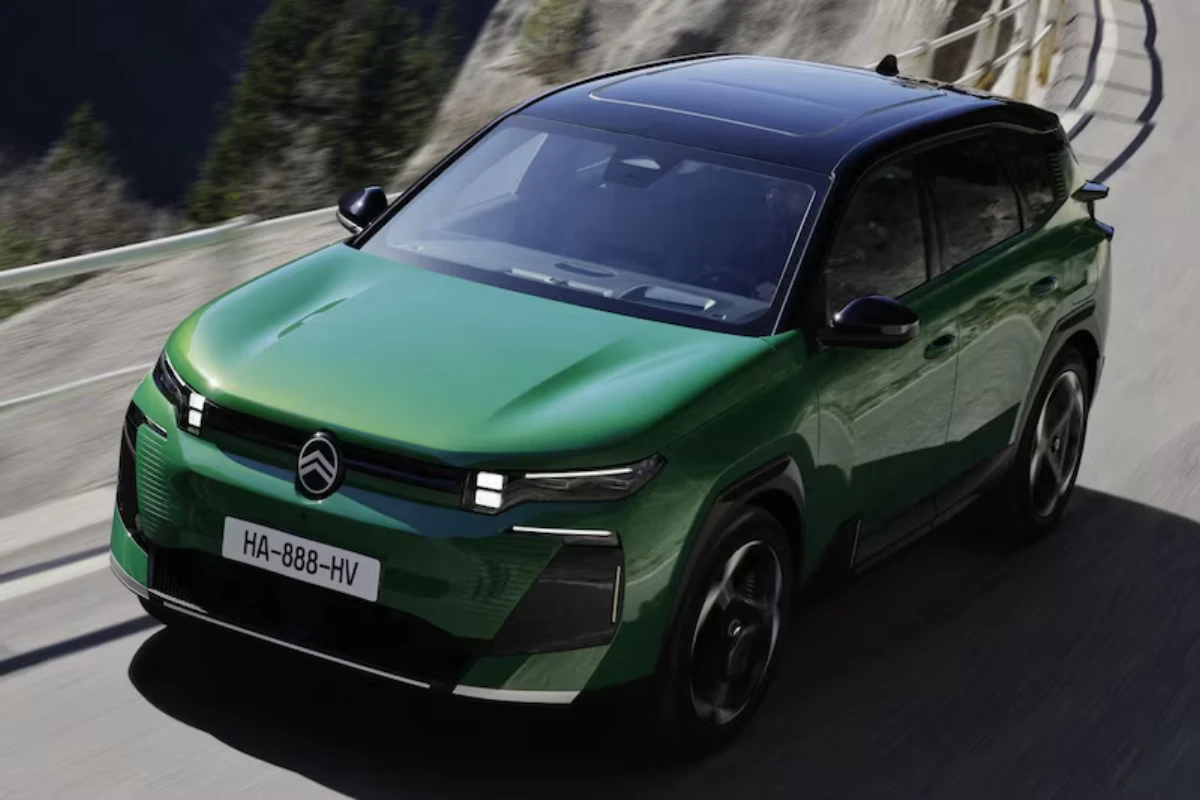 Actieshot van groene Citroën C5 Aircross plug-in hybrid SUV rijdend op bochtige bergweg, toont dynamische prestatiemogelijkheden en modern voorgevel-design van het 195pk geëlektrificeerde gezinsvoertuig