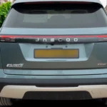 Achteraanzicht van lichtblauwe Jaecoo 7 PHEV SUV met merkletters, PHEV-badge en moderne LED-achterlichten