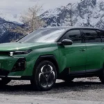 Vooraanzicht driekwart van groene Citroën C5 Aircross plug-in hybrid in besneeuwde bergomgeving, met kenmerkende chevron-logo, moderne LED-koplampen en stoere SUV-verhoudingen van het €42.690 gezinsvoertuig
