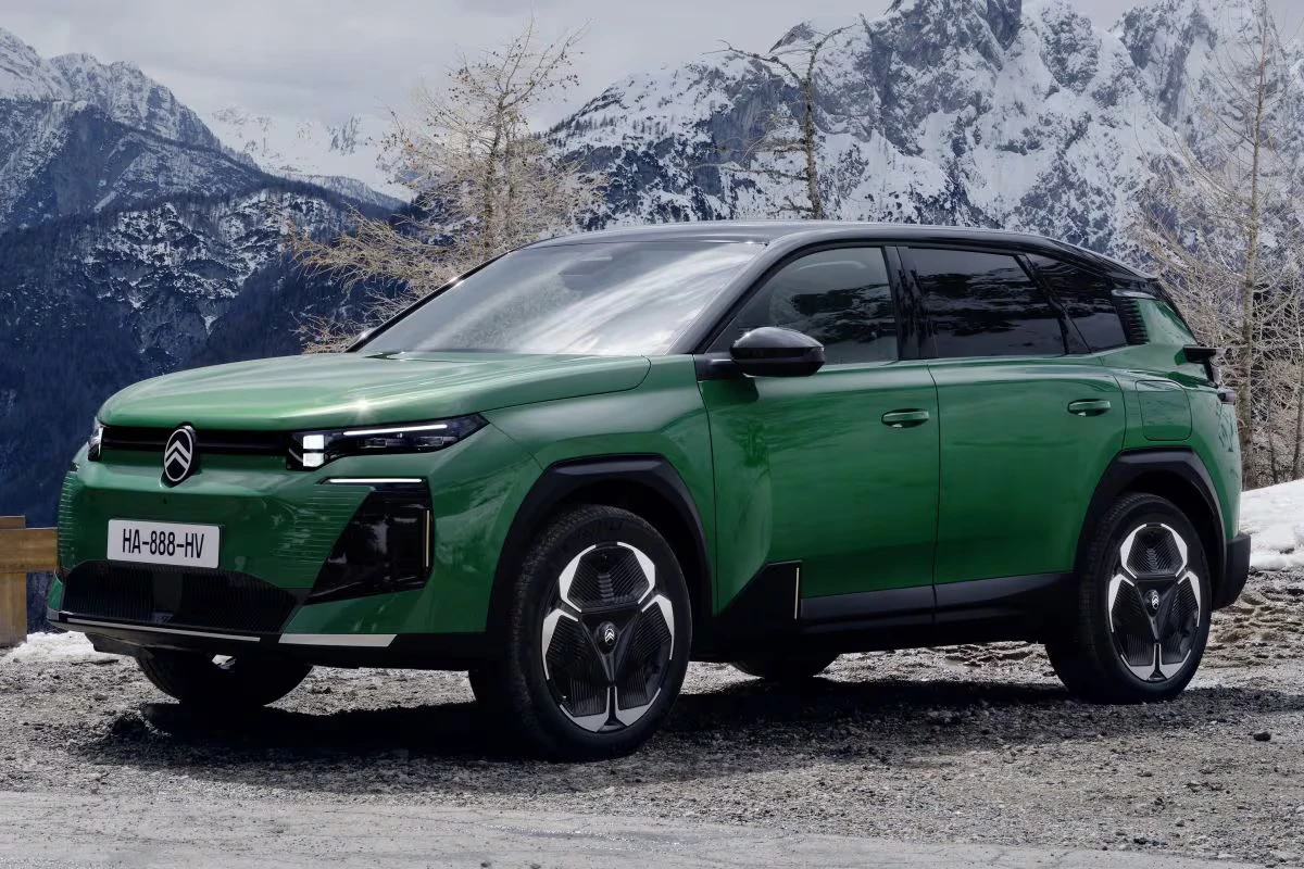 Vooraanzicht driekwart van groene Citroën C5 Aircross plug-in hybrid in besneeuwde bergomgeving, met kenmerkende chevron-logo, moderne LED-koplampen en stoere SUV-verhoudingen van het €42.690 gezinsvoertuig