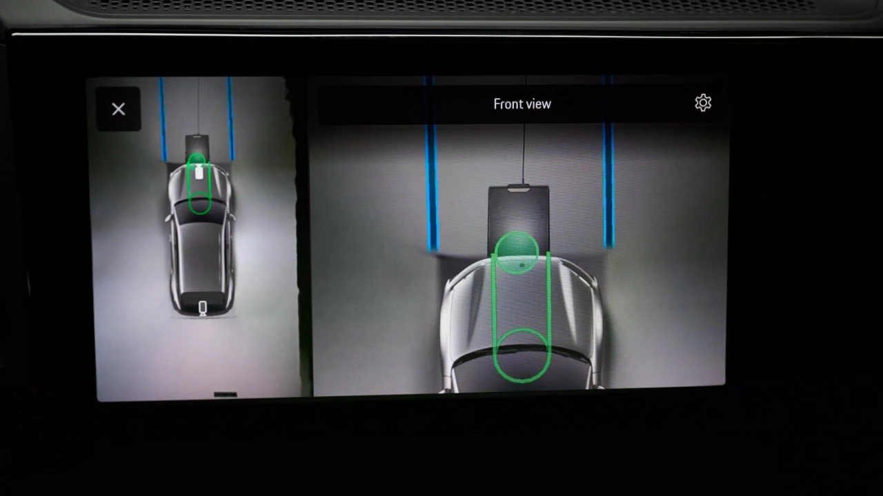 Het geavanceerde camerasysteem van de Porsche Cayenne Electric dat vooraanzicht uitlijningscirkels toont voor precieze positionering boven de draadloze oplaadpad, met de innovatieve parkeerassistent technologie geïntegreerd met inductief opladen.