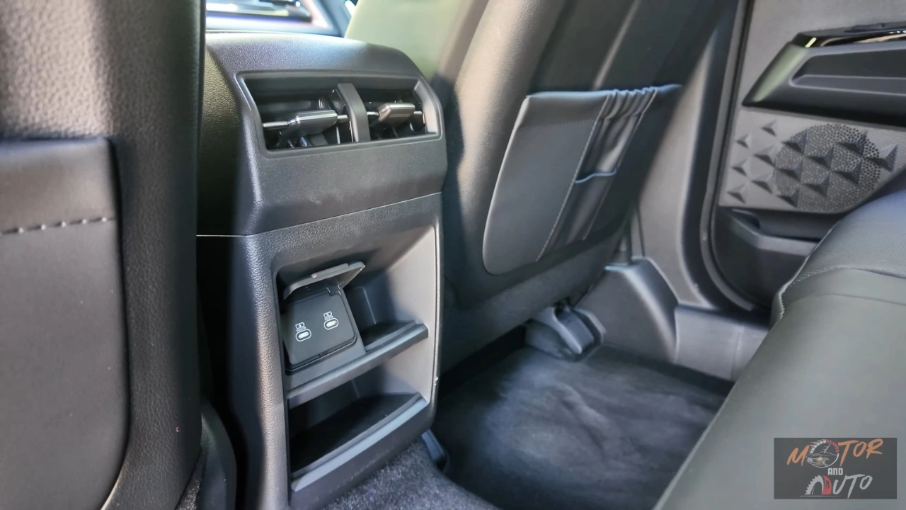 Detailopname van 2025 KGM Torres Hybrid achter middenconsole met twee USB-C oplaadpoorten gemonteerd onder klimaatroosters met grijs en zwart interieur afwerking