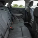 2026 Audi Q3 achterpassagiersstoelen met zwarte lederen bank met diamantpatroon stiksels, middelste armsteun met bekerhouders, voldoende beenruimte en hoofdruimte, achterklimaat roosters en deuropbergruimte zakken