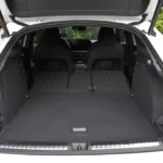 2026 Audi Q3 Sportback laadruimte met achterstoelen plat gevouwen met maximale 1.386L capaciteit, continue vlakke laadvloer, zwart tapijt oppervlak, zijopbergruimte zakken en lading tie-down punten