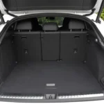 2026 Audi Q3 Sportback bagageruimte met achterstoelen omhoog met 488L laadruimte, vlakke zwarte tapijtvloer, zwart tonneau-deksel, zijopbergnetten, LED-verlichting en achterstoelrug vrijgave hendels