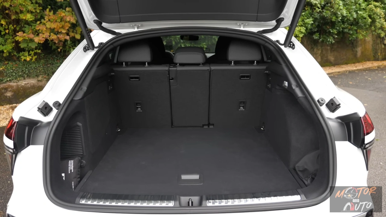 2026 Audi Q3 Sportback bagageruimte met achterstoelen omhoog met 488L laadruimte, vlakke zwarte tapijtvloer, zwart tonneau-deksel, zijopbergnetten, LED-verlichting en achterstoelrug vrijgave hendels