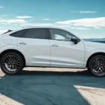 Profielzicht van de 2026 Audi Q3 Sportback met nadruk op zijn 4.530mm lengte, coupé-achtige daklijn die 3cm lager uitkomt dan standaard Q3, karakterlijn van voor naar achter, 20-inch veelspaaks wielen, zwarte spiegelkappen en plug-in hybride badges.