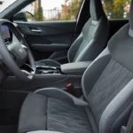 2026 Audi Q3 bestuurders- en passagierssportstoelen in zwart met microvezelige middenpanelen met diamantpatroon stiksels, lederen zijsteunen, geïntegreerde hoofdsteunen en zichtbare stoelaanpassingsbedieningselementen op buitenste zijsteun