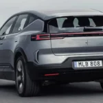 Achteraanzicht van driekwart van rijdende 2026 Polestar 3 elektrische SUV met LED-achterlichten