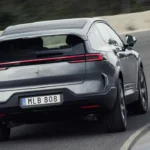 Achteraanzicht van rijdende 2026 Polestar 3 elektrische SUV op weg met achterlichten