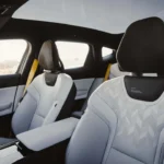 Interieur voorstoelen van de 2026 Polestar 3 met duurzame premium bekleding, panoramisch glazen dak en Zweeds gouden performance gordels die de top-tier Performance-variant aangeven.