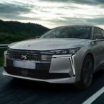 De DS No. 4 in beweging, met nadruk op zijn overheersende wegaanwezigheid met de verlengde motorkap, bredere stance, en aerodynamisch voorzijde design dat technologie en elegantie combineert.